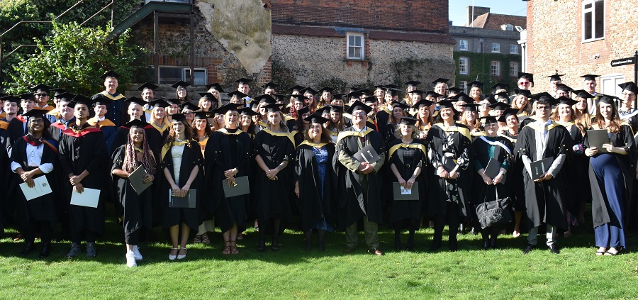 The class on 2023 graduate from University Studies at West Suffolk College in the grounds of the cathedral in Bury