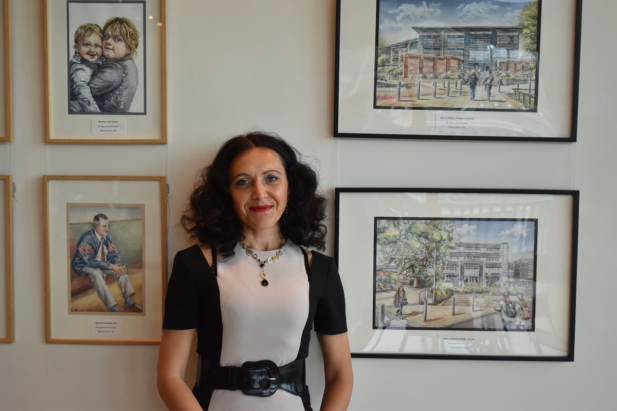 Agnieszka Procajlo at the Apex with some of her paintings - lady with curly hair surrounded by four paintings