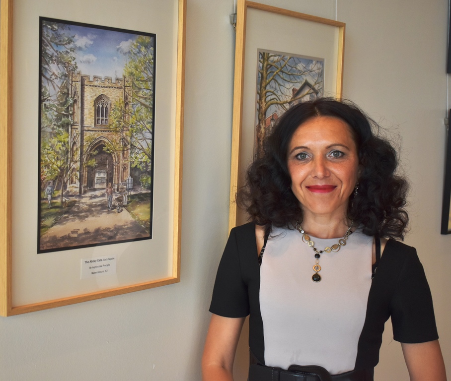 Agnieszka Procajlo at the Apex with some of her paintings - lady with curly hair surrounded by four paintings