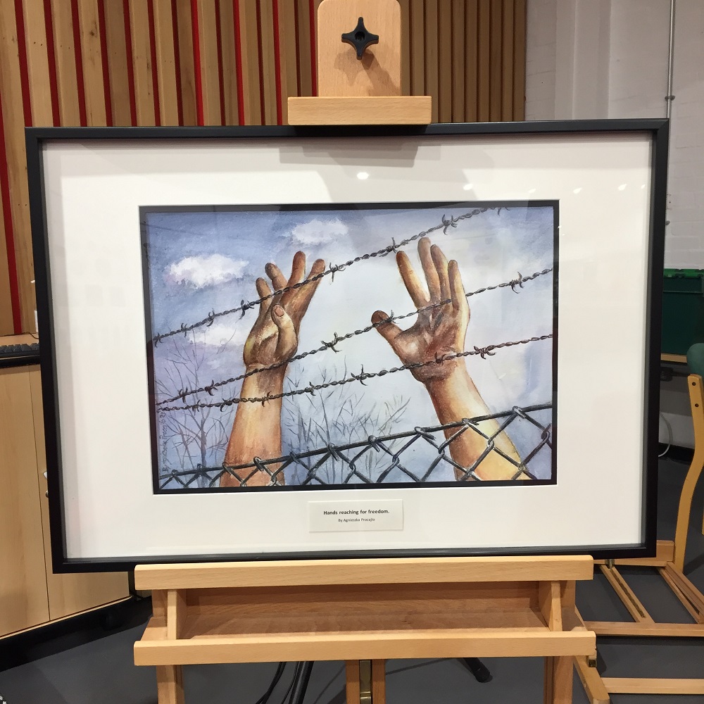 A watercolour painting of two hands reaching behind barbed wire