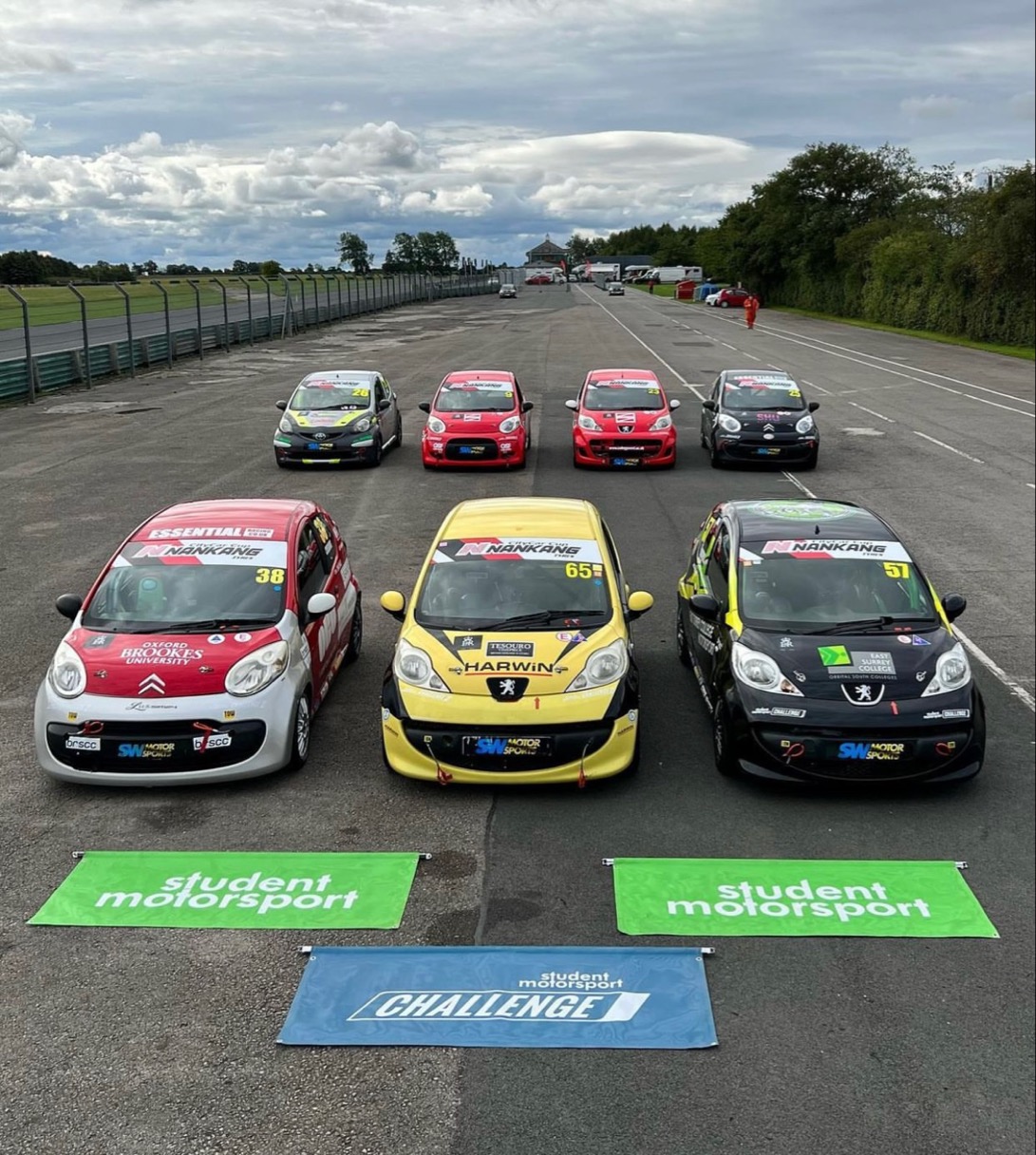 Racing cars lined up posing on track