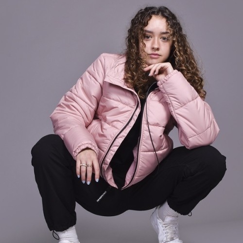 photo of a person crouched in a pink jacket and black trousers