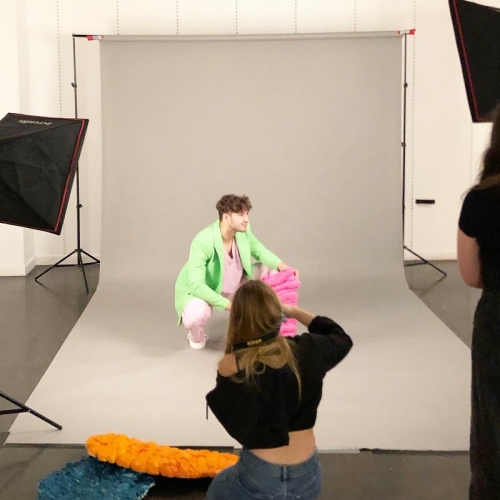 photographer taking an image of a person in a green jacket crouched