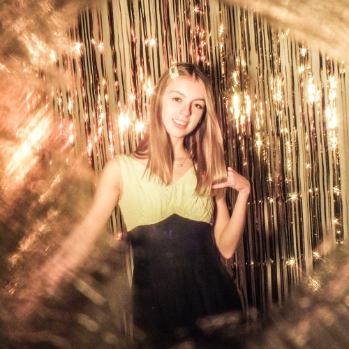 Person in yellow and black dress posing to the camera