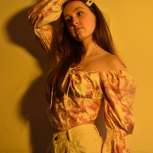 Person posing with yellow attire and a yellow background
