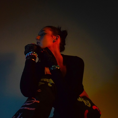 Photo of a person sat down and posing with a red glow