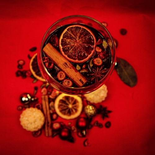 Photo of a top down perspective of a glass with fruit, sticks, plants in and around it