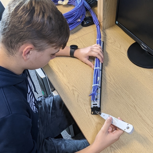 Photo of a person inspecting wires at a desk