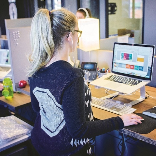 Photo of a person sitting at a desk with a laptop